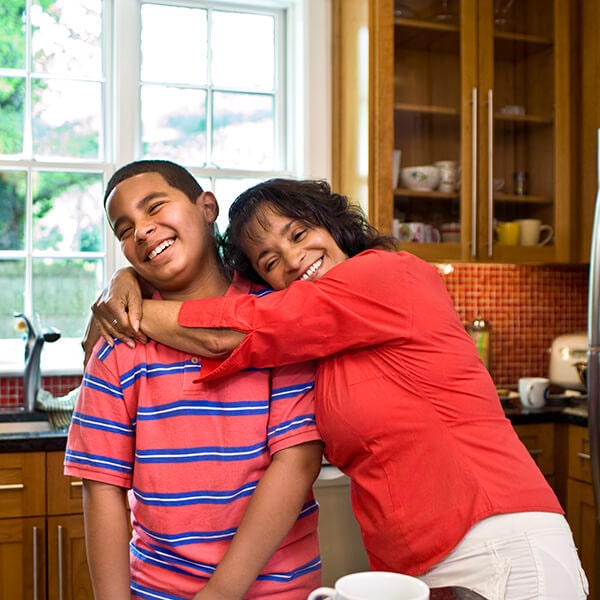 A mom hugging her son in the kitchen while they are sitting and getting ready to visit Farm Park Pediatric Dentistry